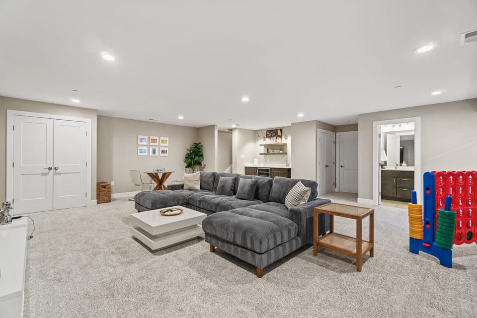 Large basement hangout area with giant Smart TV, oversized games, bar, full bathroom and game table