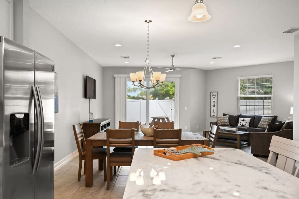 Open-concept dining and living area with modern furnishings and natural light.