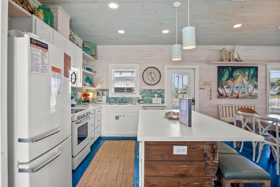 Fully equipped coastal kitchen with ample counter space and bar seating — perfect for vacation cooking and cocktails!