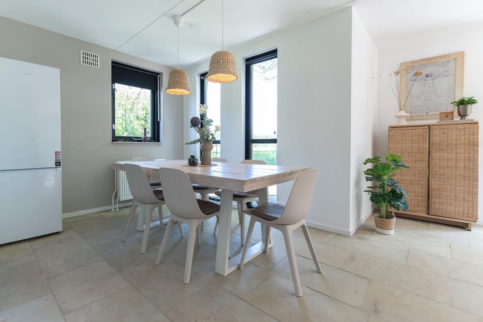Bright windows, soft tones, and natural textures make this dining room a peaceful, stylish space perfect for morning coffee or evening meals.