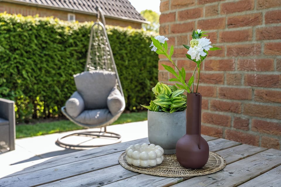 Style meets serenity—this cozy patio corner blends natural textures, soft greenery, and modern comfort for the perfect outdoor unwind.