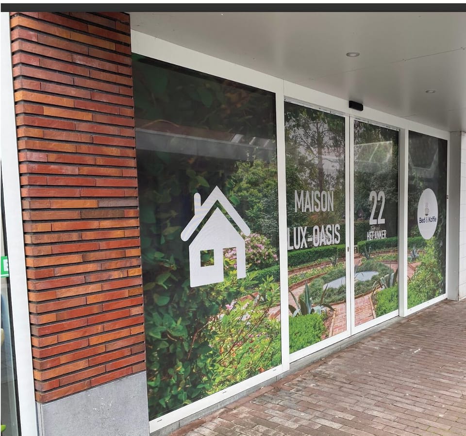 This storefront serves as the main spacious access to the building, featuring wide glass doors and windows adorned with a lush greenery design that creates a welcoming and modern atmosphere making it easy to locate and identify.
