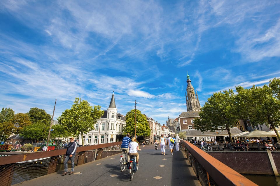 Cross Breda’s charming bridges to discover a vibrant city with cozy cafés, scenic streets, and the historic grandeur of the Grote Kerk.