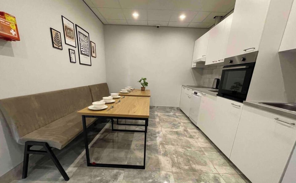 Fully equipped shared kitchen featuring ample seating, modern appliances, and a welcoming dining area for all guests.