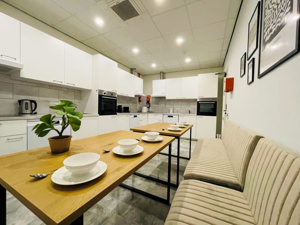 Fully equipped shared kitchen with modern appliances and a spacious dining area for communal meals.