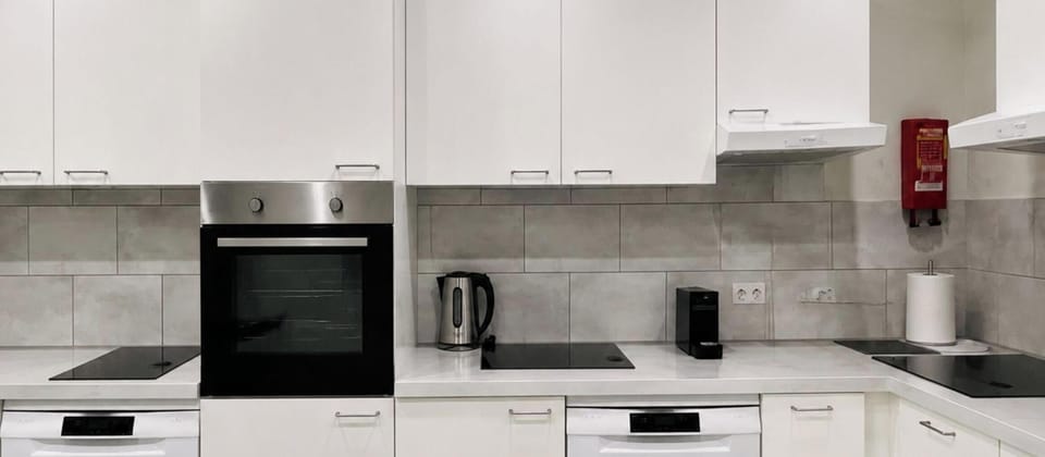 Bright shared kitchen with multiple cooking stations and modern amenities.