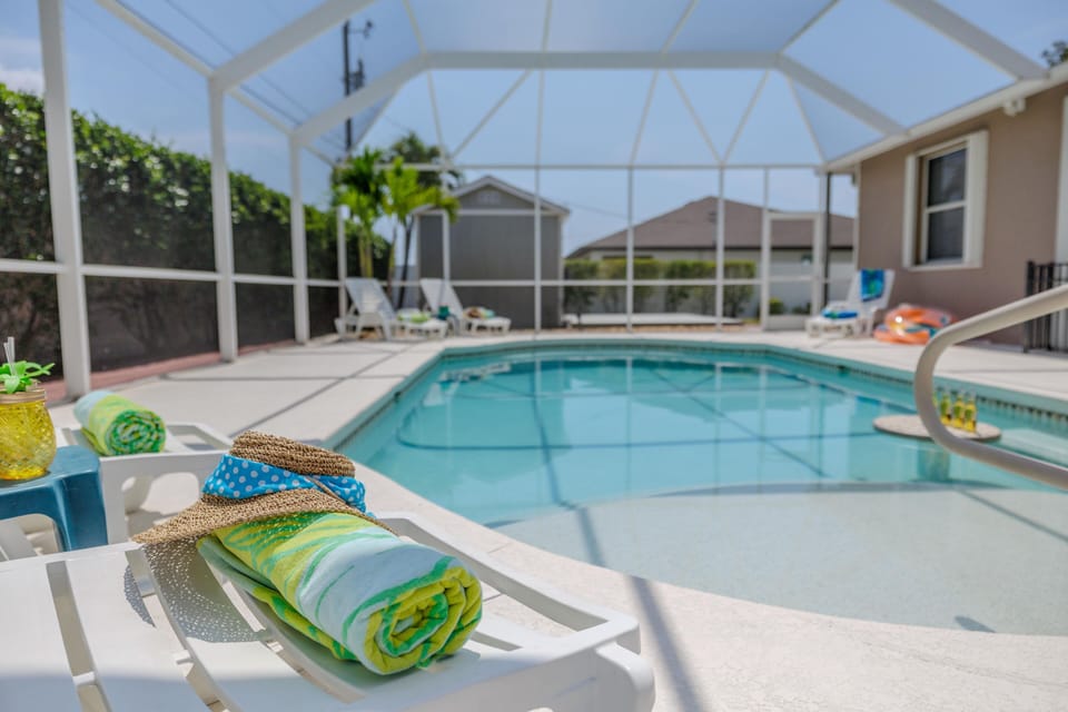 Poolside Relaxation - - Inviting screened in pool with a spacious deck, perfect for lounging and soaking up the sun
- Comfortable seating and vibrant towels add a touch of style and comfort
- Ideal for relaxing afternoons or entertaining family and friends