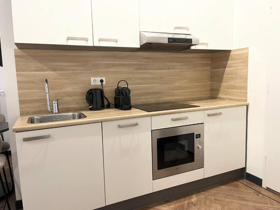 A modern kitchen with essential appliances, including a microwave and sleek cabinets, designed for comfort and functionality.