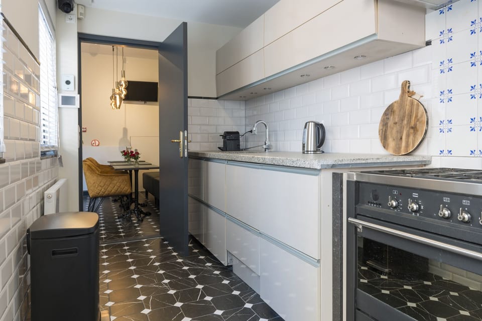 Kamer met karakter en gedeelde voorzieningen—verblijf bij Bed en Koffie in Hotel Centrum Tilburg, dicht bij Poppodium 013 en Efteling, met toegang tot een gedeelde keuken en groene tuin.