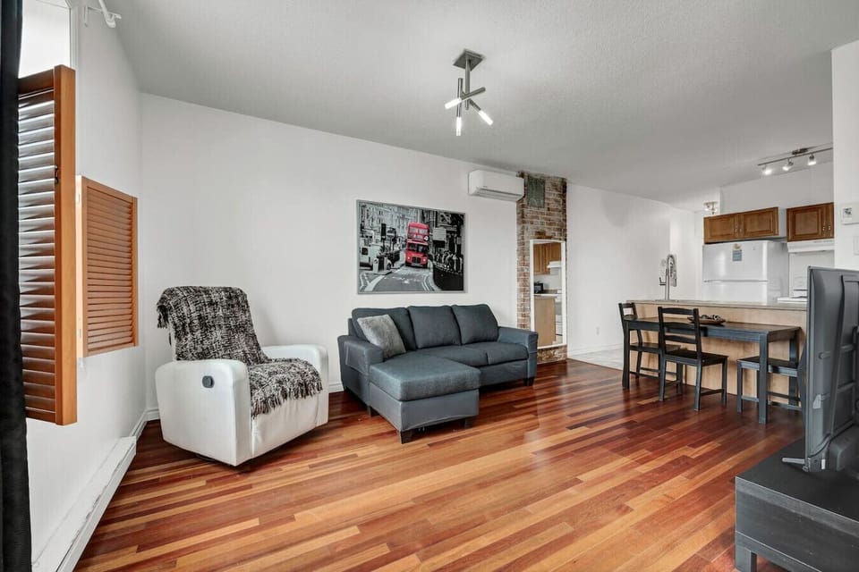 Open-concept living area flowing into the kitchen, with a recliner, sofa, and dining nook.