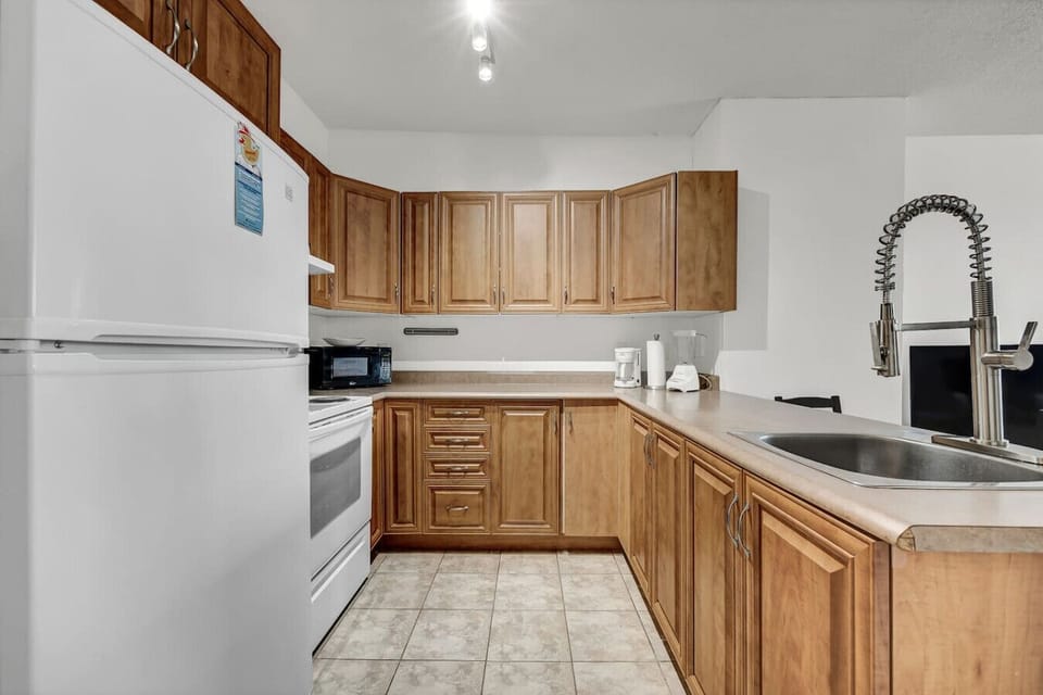 Fully equipped second kitchen with ample cabinet storage and tile flooring.