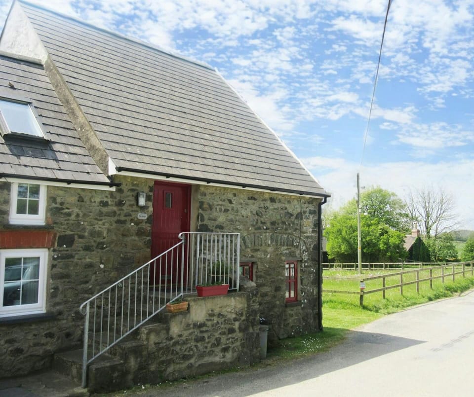 Exterior of The Steps cottage with stairs and handrail leading up to front door