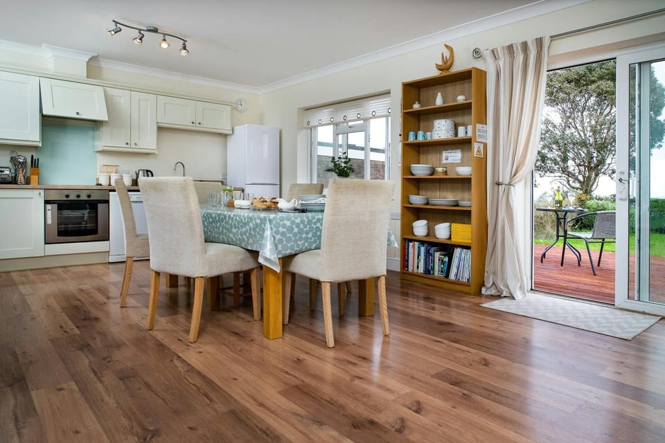 Safe Haven living area with dining table and chairs, kitchen, patio doors