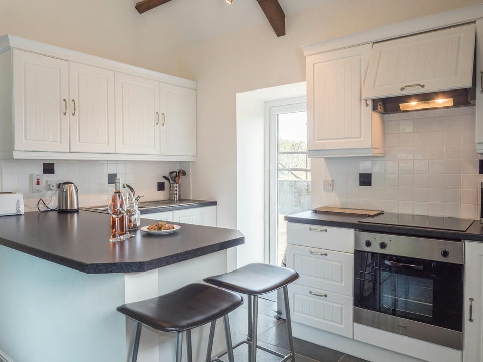 Kitchen area with breakfast bar and stools, cooker, sink