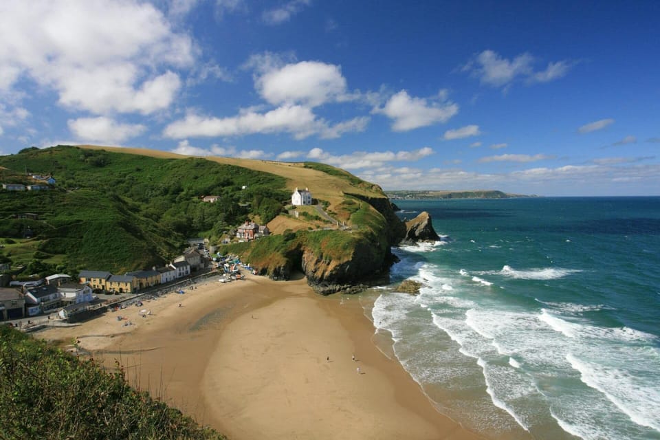 View from high above Llangrannog beach with village and houses to left sea to the right