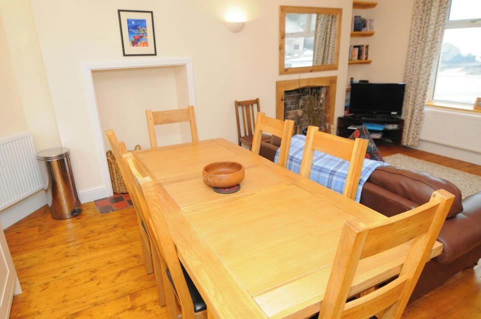 Open plan lounge/dining area with table seating eight, sofa and TV on unit