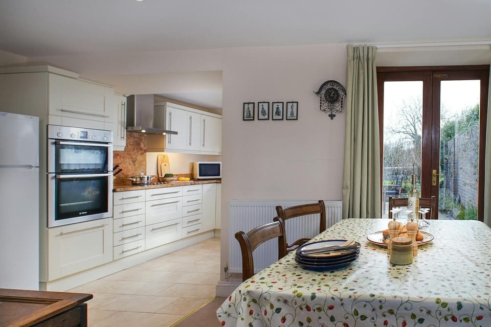 Glandwr dining table and chairs by patio doors at Glandwr, kitchen to the side