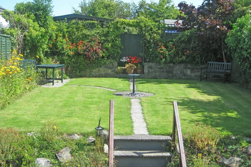 Garden from patio with table and benches