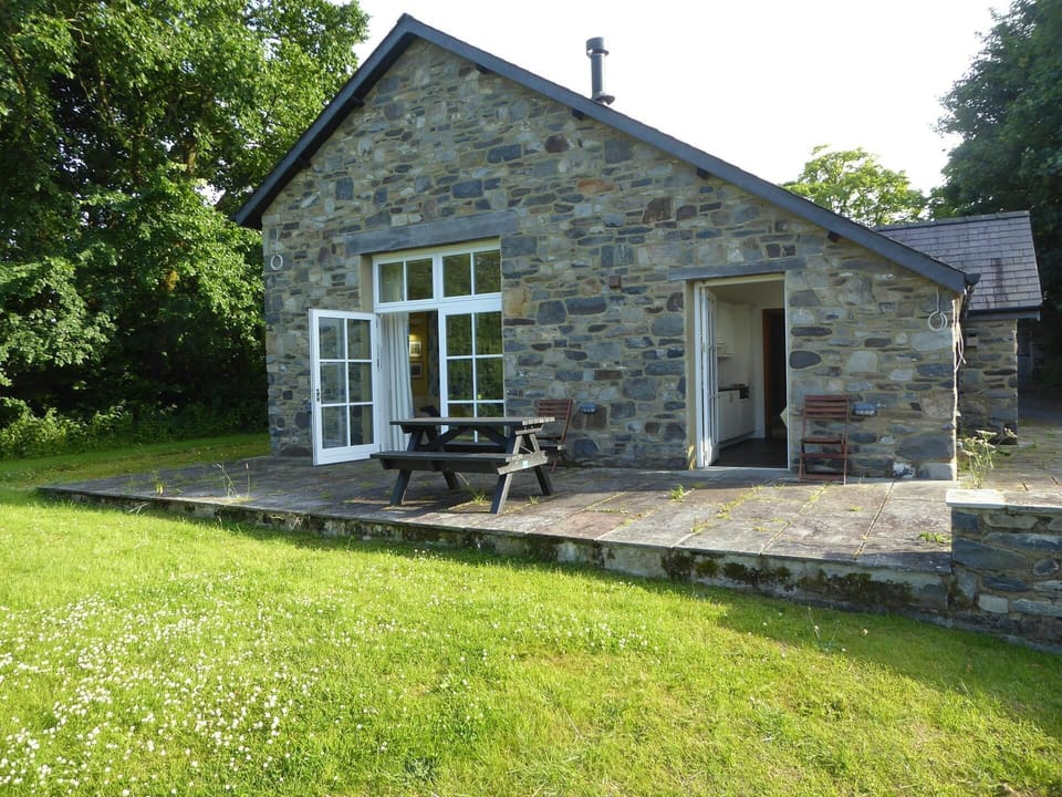 Ty Cellin from the outside with patio area and bench