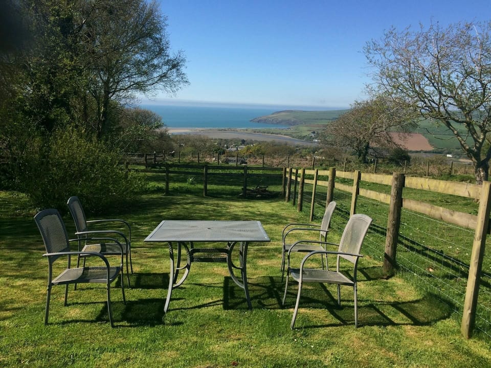 View from the garden, with sea views, outdoor table and four chairs