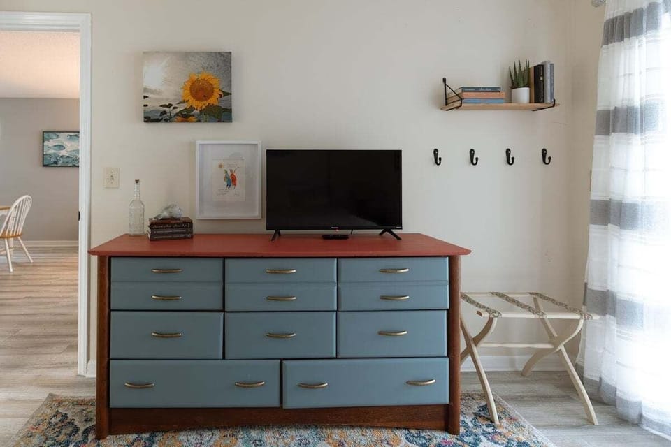 Spacious primary bedroom with plush bedding, natural light, and private bathroom access. A peaceful retreat for restful nights after exploring Carolina Beach