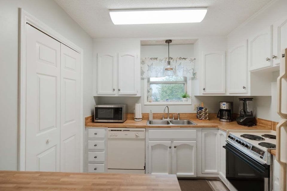 Fully stocked kitchen featuring modern appliances, cookware, and everything you need for effortless vacation meals. Includes garbage disposal, full‑size fridge, and plenty of counter space.