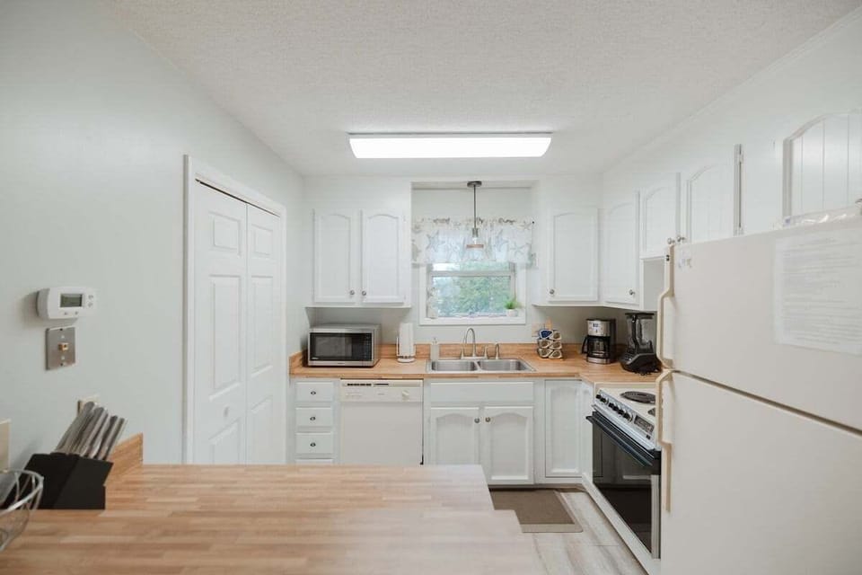 Fully stocked kitchen featuring modern appliances, cookware, and everything you need for effortless vacation meals. Includes garbage disposal, full‑size fridge, and plenty of counter space.