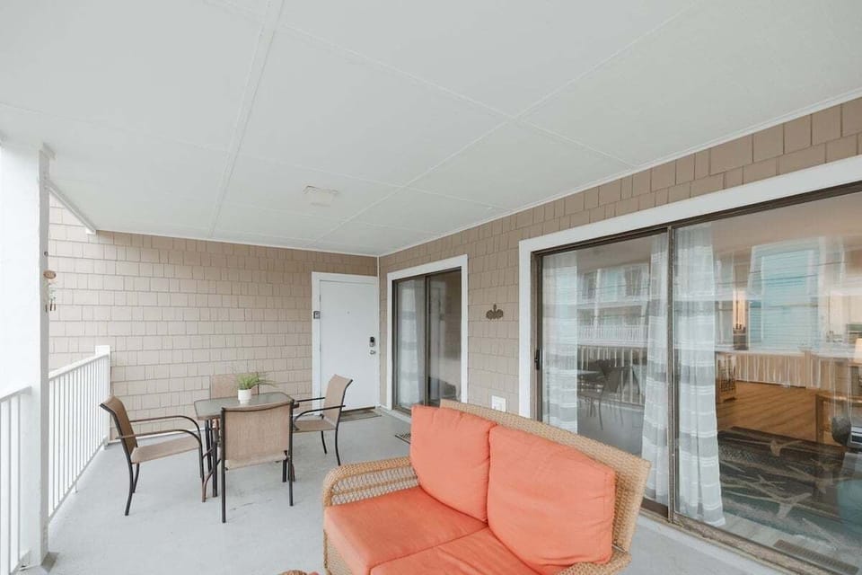 Spacious primary bedroom with plush bedding, natural light, and private bathroom access. A peaceful retreat for restful nights after exploring Carolina Beach