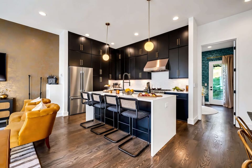 Island with bar stools, plenty of counter space, and an open view into the living room. This kitchen is built for group cooking and gathering