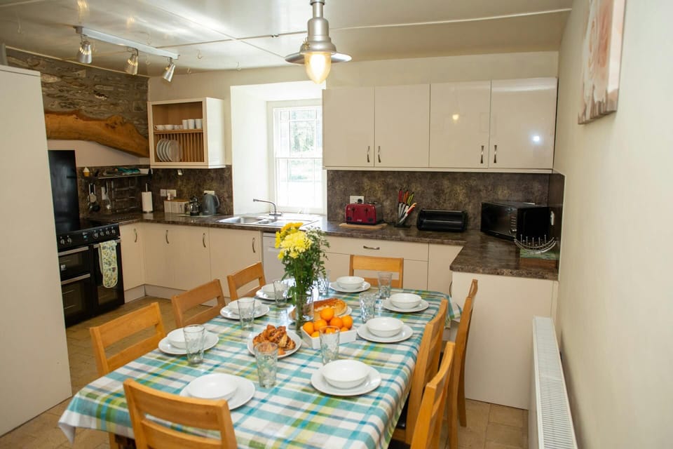 Fitted kitchen/dining area: range cooker, microwave, toaster, kettle, dining table with eight chairs