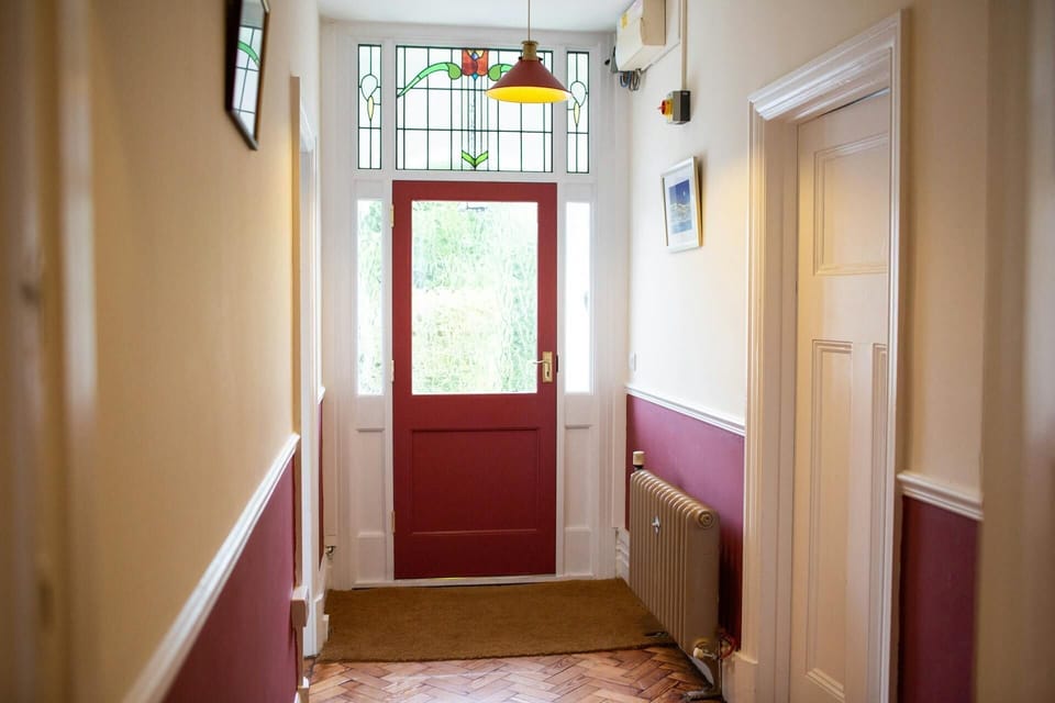 Stained glass fan lights above front door. Parquet flooring