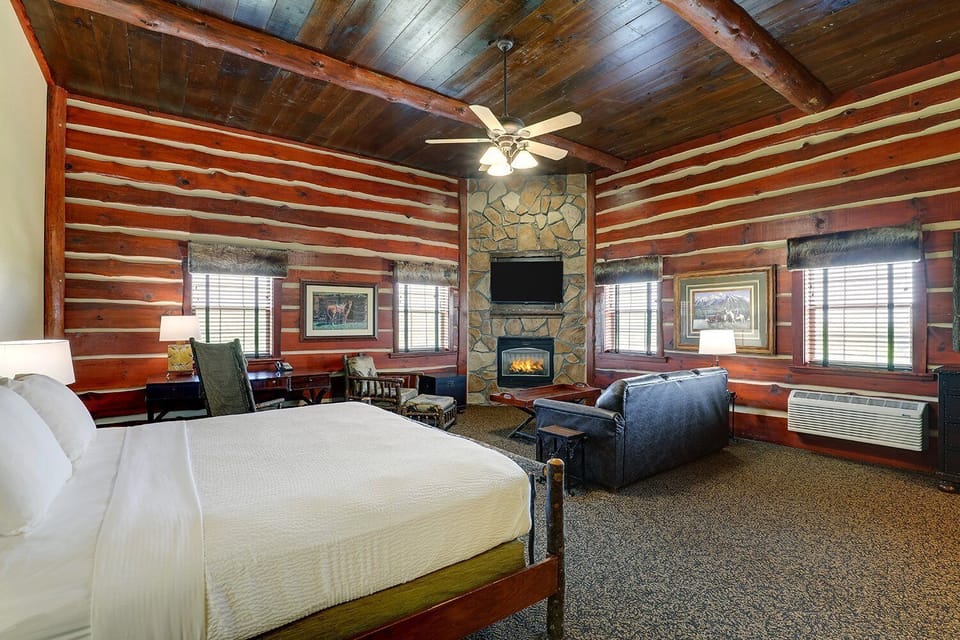 Escape to a rustic retreat with fireplace glow and plush bed.