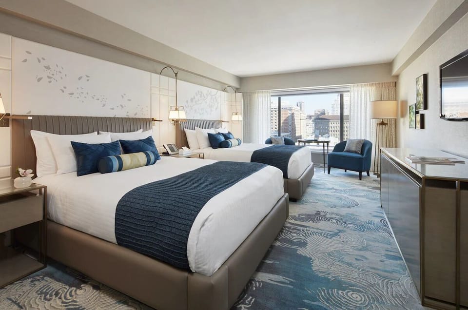 Unwind in plush beds with sunlit city views.