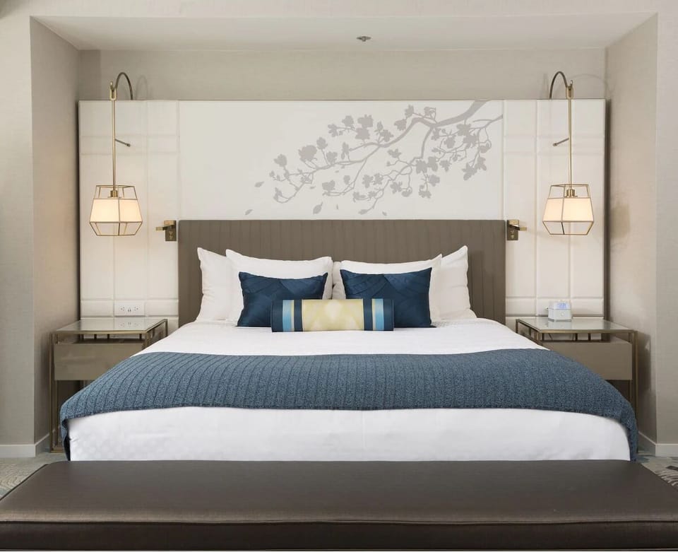 Unwind in crisp linens beneath calming designer wall art.