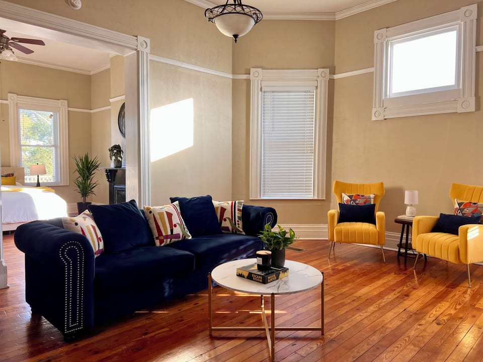 Living space with blue couch and yellow chairs