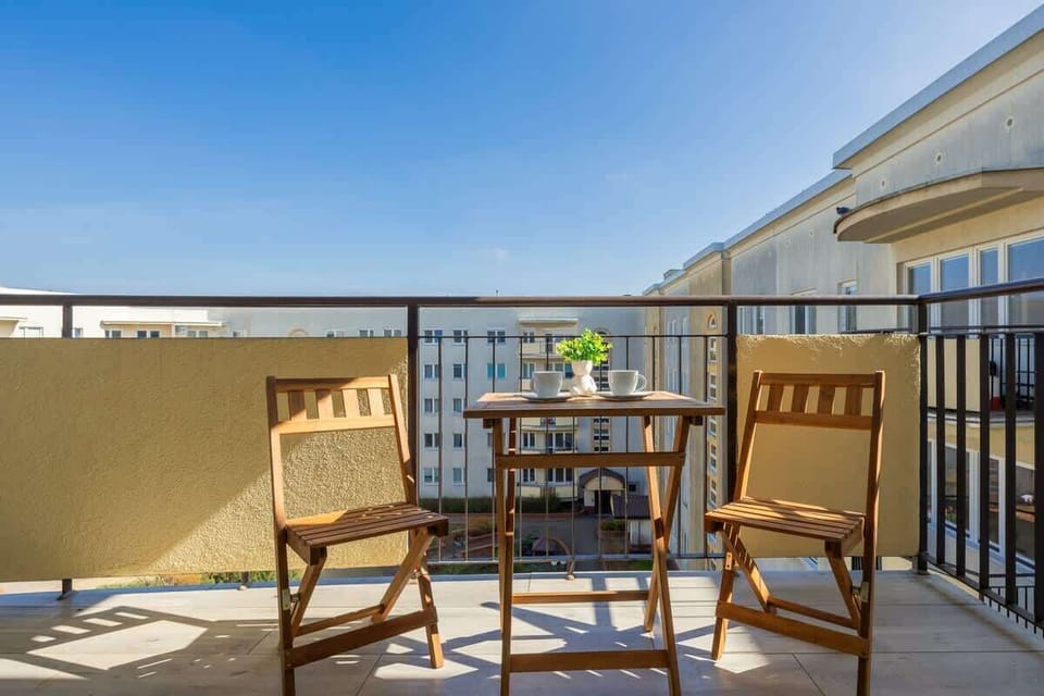 Outdoor seating on a balcony with a table and chairs.