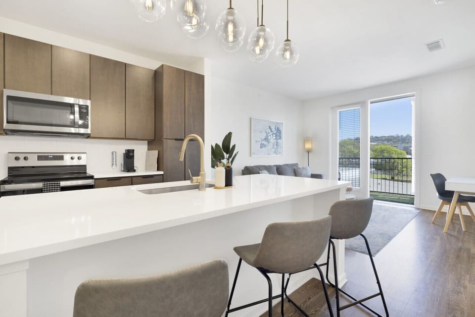 Modern kitchen with a sleek dining area, perfect for cooking, serving, and enjoying meals in style during your short-term rental stay