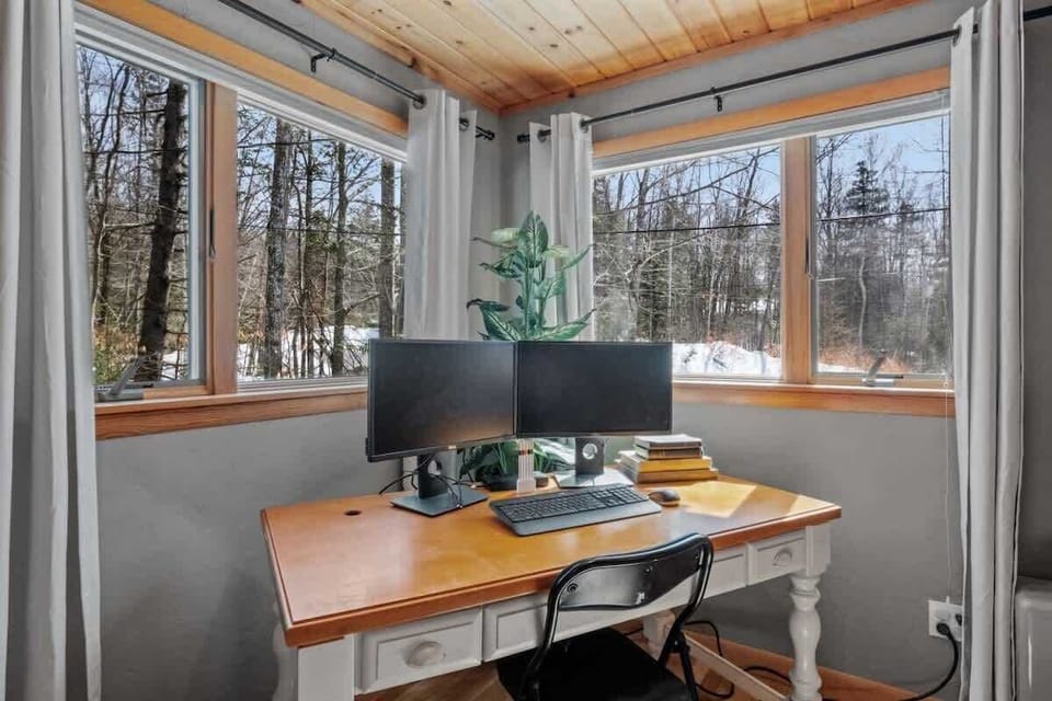 Our primary bedroom features a workstation with dual monitors and natural light for a productive stay
