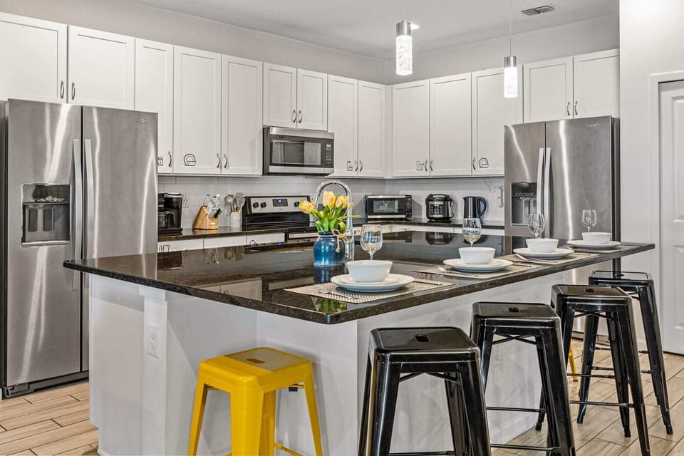 Fully Equipped Kitchen With Double Fridge And Sleek Countertops