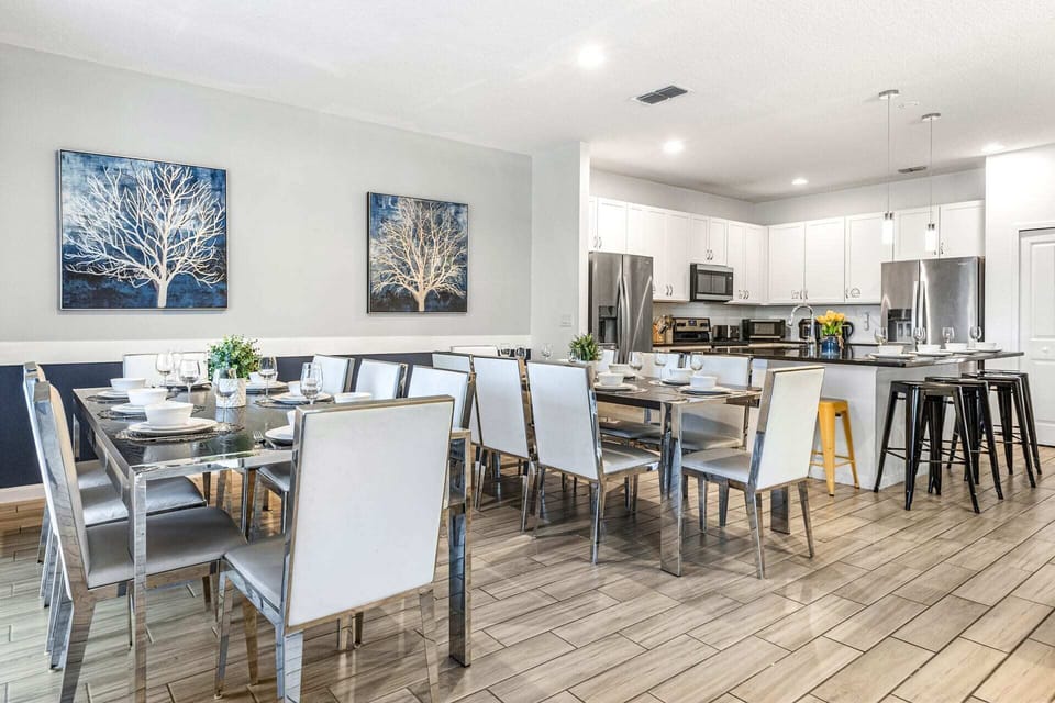 Elegant Dining Area With Seating For Large Groups And A Fully Equipped Modern Kitchen Nearby