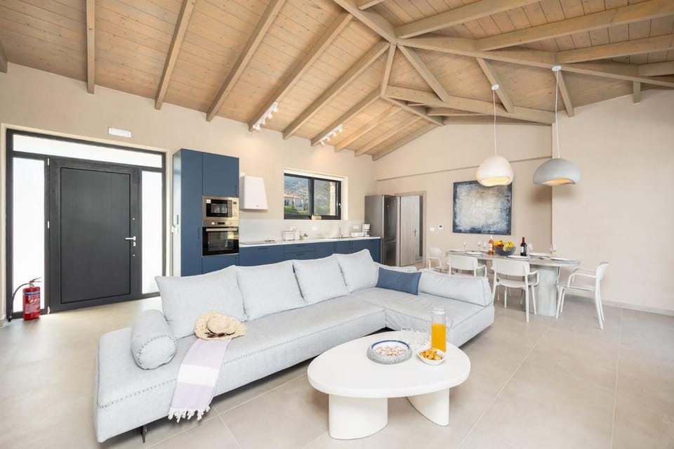 Open-plan living room with sofa, dining area, kitchen, A/C, WiFi internet, and satellite TV
