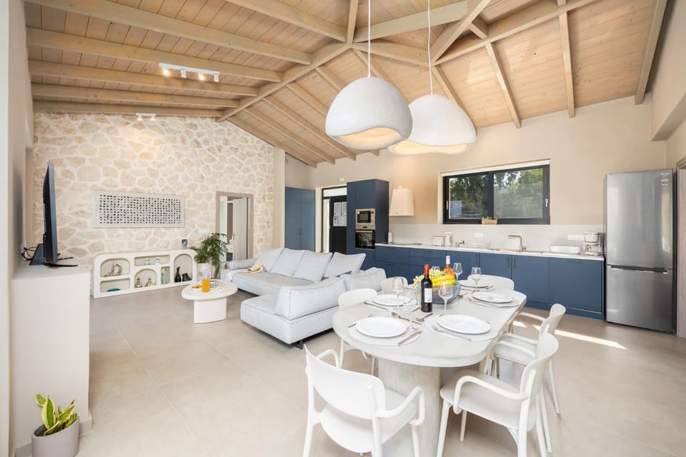 Open-plan living room with sofa, dining area, kitchen, A/C, WiFi internet, and satellite TV