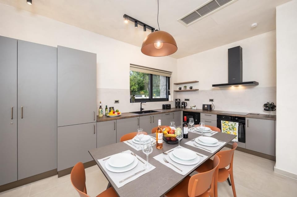 Open-plan living room with sofa, dining area, kitchen, A/C, WiFi internet, and satellite TV
