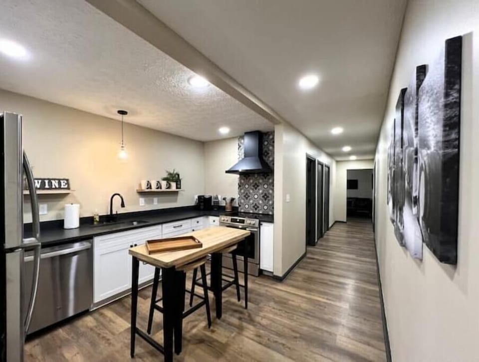 Full kitchen with new appliances and seating for two at the island.