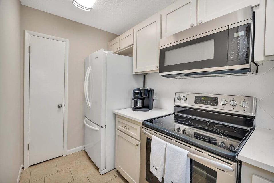 White kitchen with stainless range and refrigerator