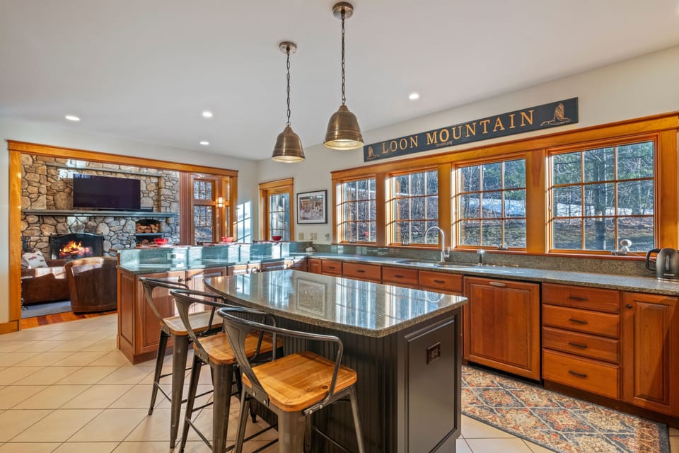 Fully equipped kitchen with granite countertops, breakfast bar seating, and plenty of space for cooking and gathering.