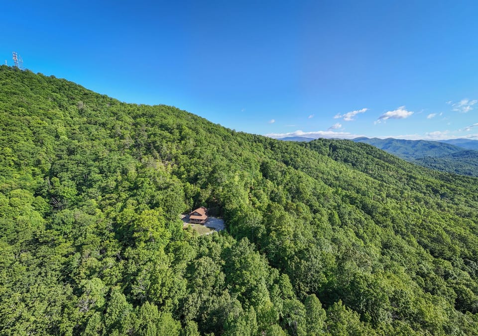 Surrounded by Forest
Elevated view showing the cabin nestled among dense mountain forest. Private wooded setting near Great Smoky Mountains National Park and NOC.