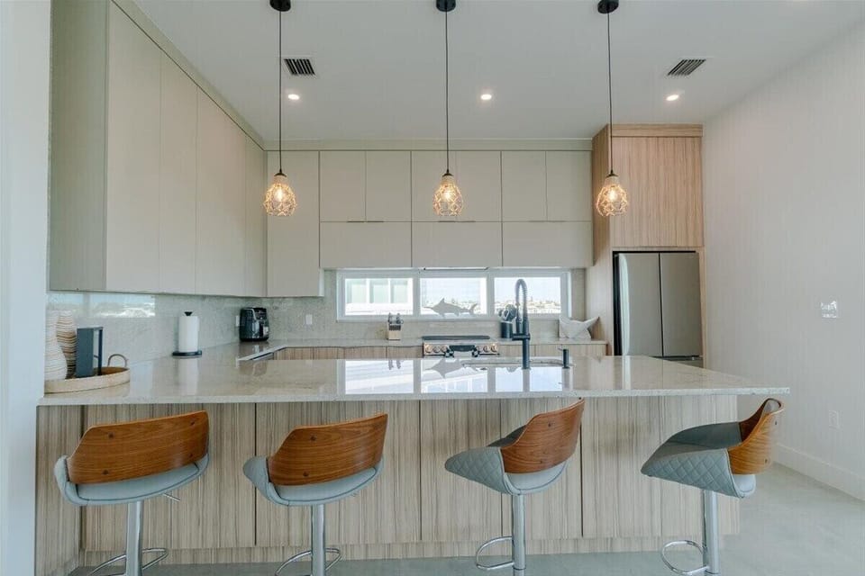 Gather around the spacious kitchen peninsula while enjoying premium finishes, pendant lighting, and modern appliances.