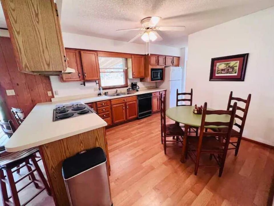 Kitchen with table that seats 4 and bar with 3 stools