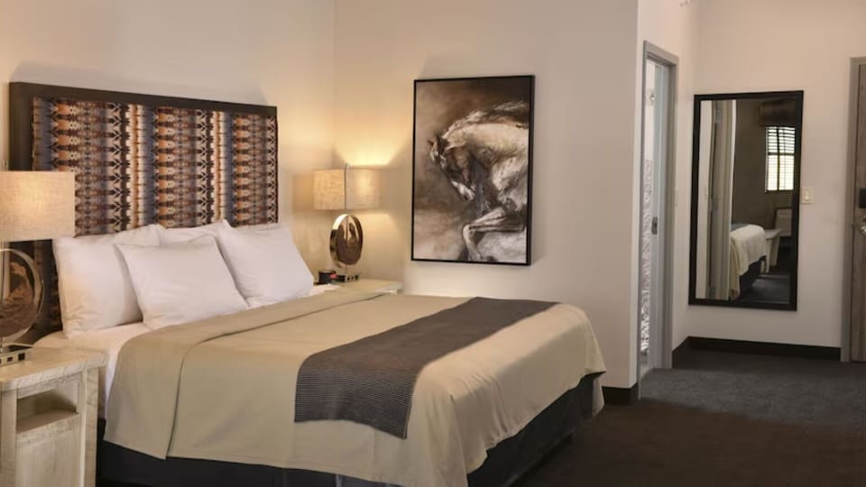 Recharge in a calming bedroom with artful accents and soft lamps.